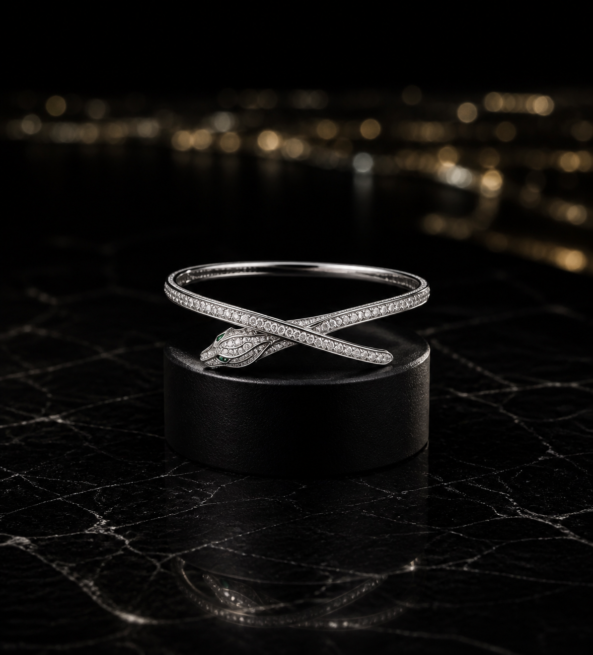 The Vigil Bracelet in rhodium-plated white gold, an open bangle closing in a small pavé panther head with emerald eyes, shown on its own.