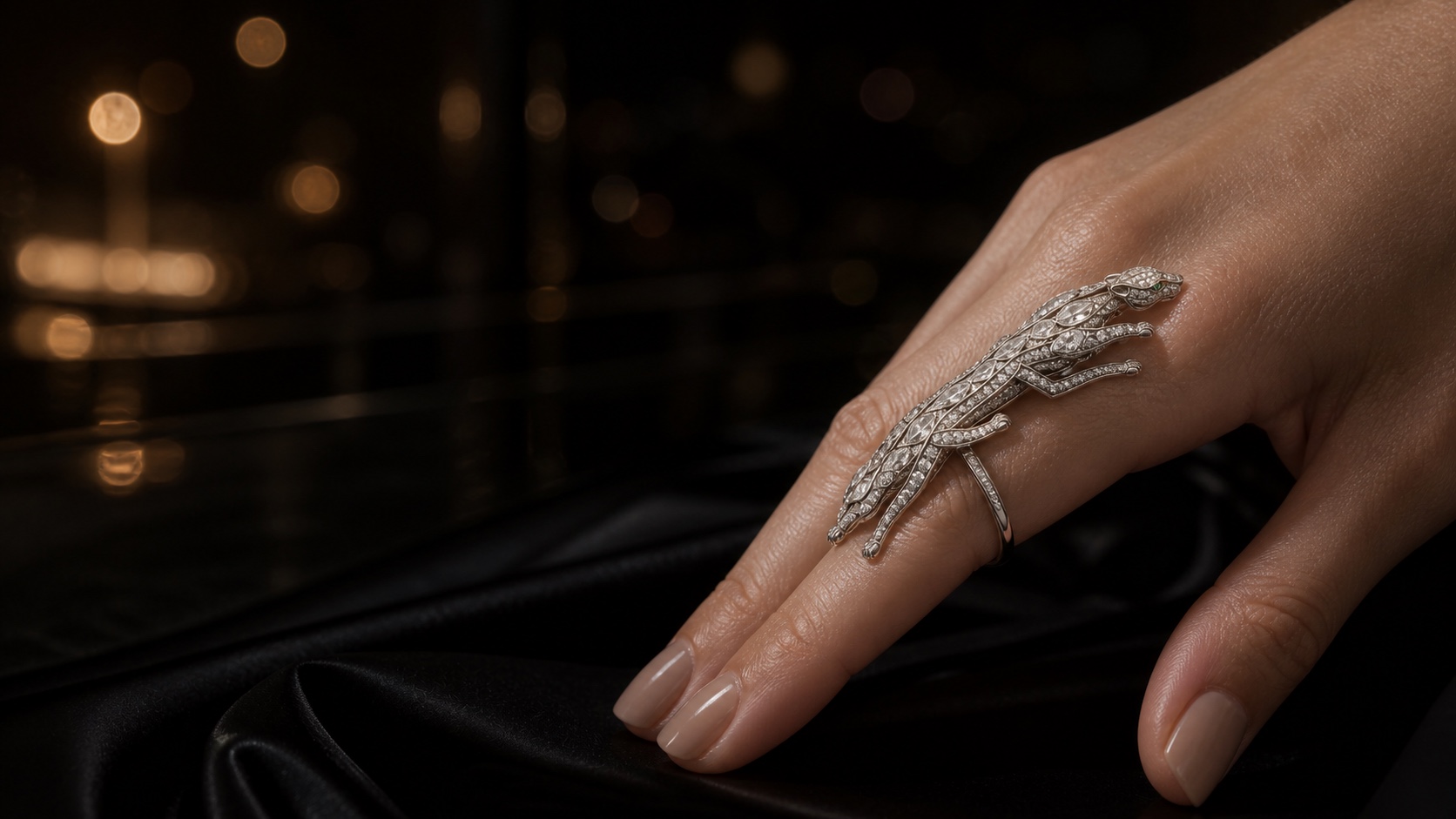 The Majesty Ring, a long articulated white-gold panther covering the length of a finger, set with pavé diamonds and emerald eyes.