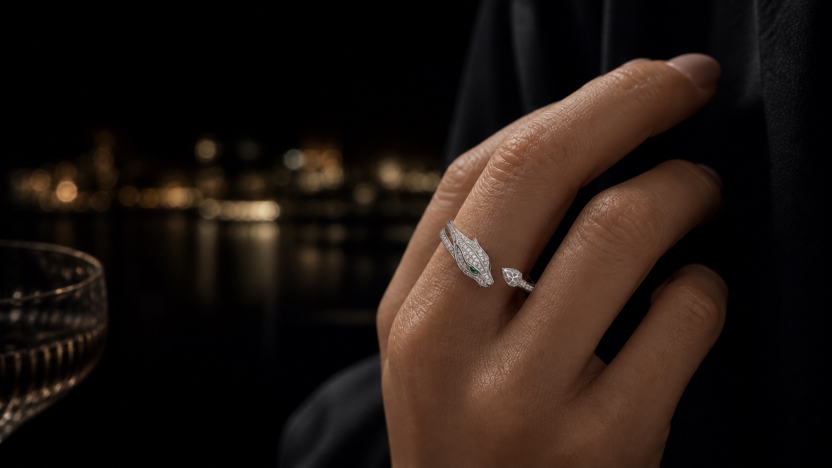 The Silhouette Ring in rhodium-plated white gold, a low-profile panther head with natural emerald eyes worn on a hand.