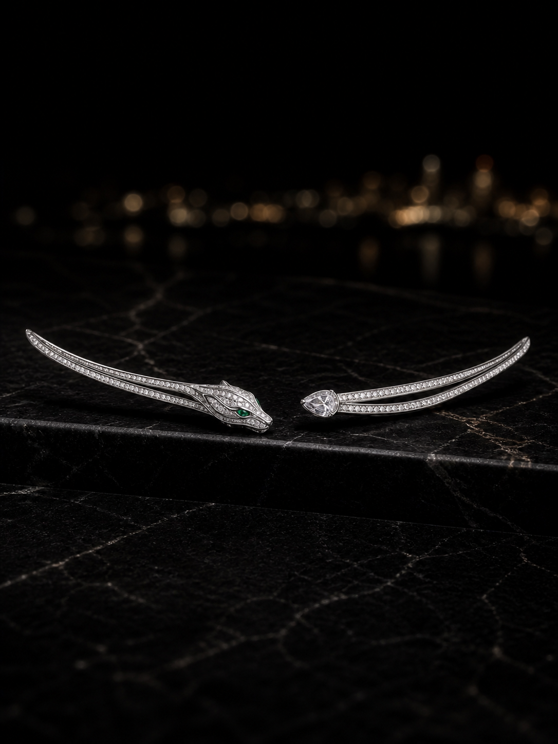 The Gaze Ear Climbers in rhodium-plated white gold with pavé diamonds and natural emerald eyes, shown on their own against a dark ground.