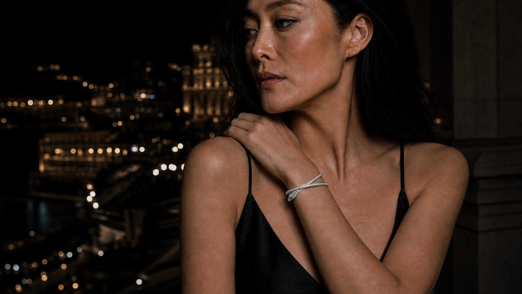 The Vigil Bracelet worn on the wrist, the white-gold bangle closing on a small pavé panther head with emerald eyes.