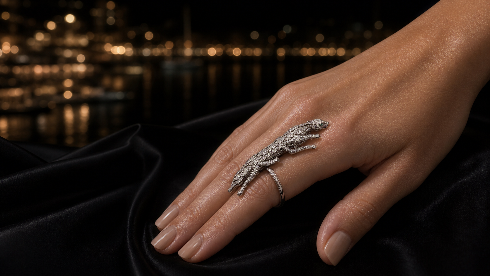 The Majesty Ring worn on a hand resting on black silk, the sculptural white-gold panther set with diamond pavé.